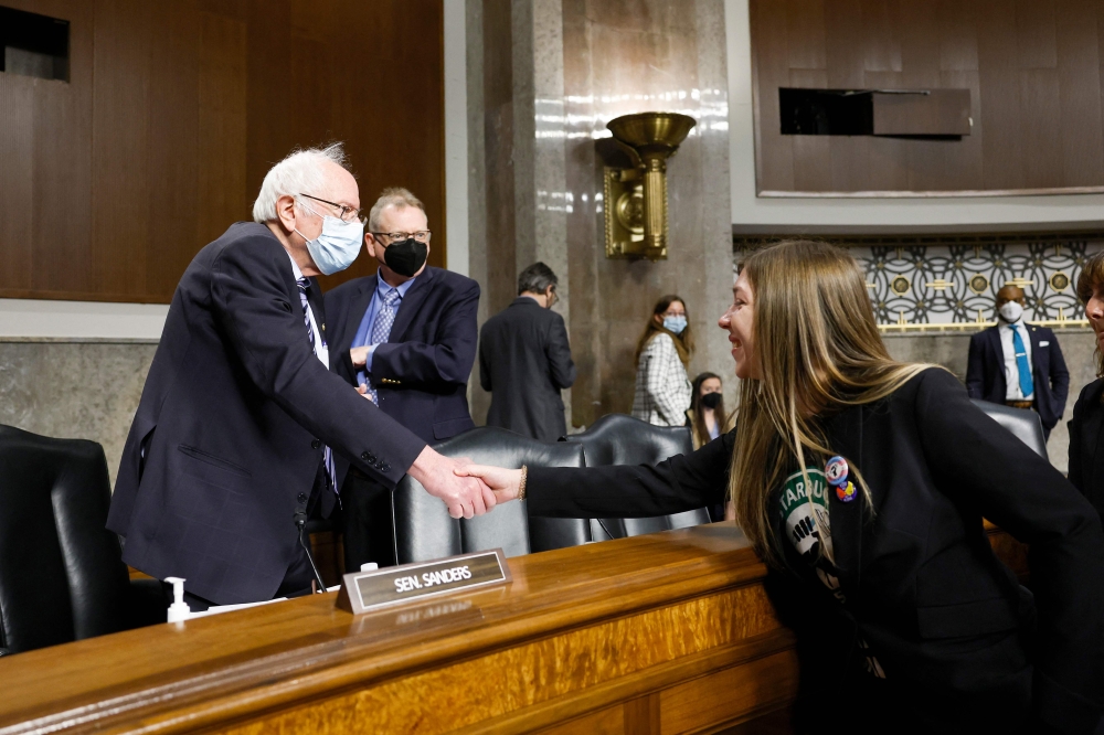 Senate Health, Education, Labor, and Pensions Committee Chairman Bernie Sanders (I-VT) greets Maggie Carter, a Starbucks barista from Knoxville, Tennessee, before the start of a second panel in the Dirksen Senate Office Building on Capitol Hill on March 29, 2023 in Washington, DC. (Photo by Anna Moneymaker / GETTY IMAGES NORTH AMERICA / Getty Images via AFP)
