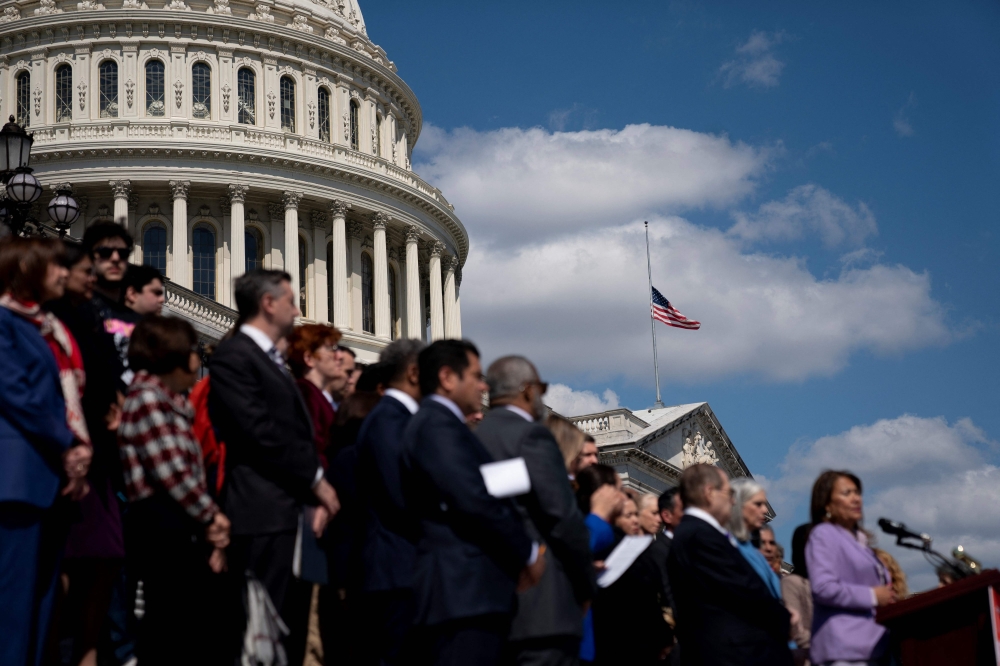 The US flag flies at half mast following the school shooting in Nashville, Tennessee, as House Democrats participate in a news conference on gun violence outside the US Capitol in Washington, DC, on March 29, 2023. (Photo by Stefani Reynolds / AFP)