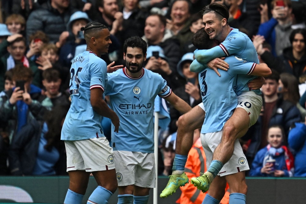 Manchester City's English midfielder Jack Grealish (R) celebrates with teammates after scoring their fourth goal during the English Premier League football match between Manchester City and Liverpool at the Etihad Stadium in Manchester, north west England, on April 1, 2023. (Photo by Paul ELLIS / AFP)