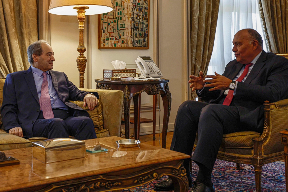 Egyptian Foreign Minister Sameh Shoukry (right) meets with his Syrian counterpart Faisal Mekdad at the ministry headquarters in Cairo, on April 1, 2023. (Photo by Khaled DESOUKI / AFP)