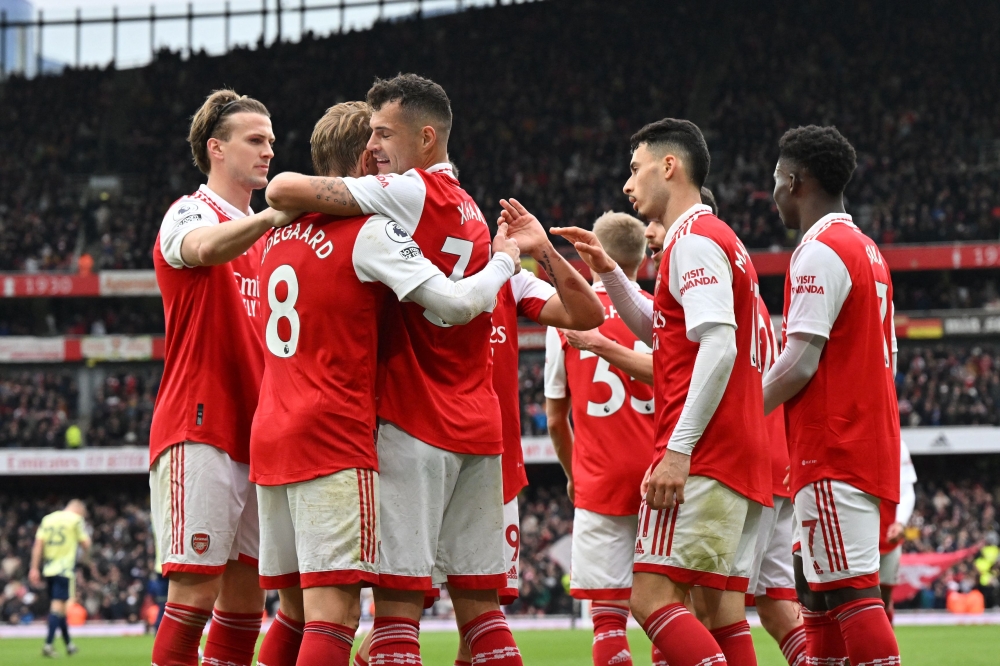 Arsenal's Swiss midfielder Granit Xhaka (third left) celebrates with teammates after scoring their fourth goal during the English Premier League football match between Arsenal and Leeds United at the Emirates Stadium in London on April 1, 2023. (Photo by Glyn KIRK / AFP) 