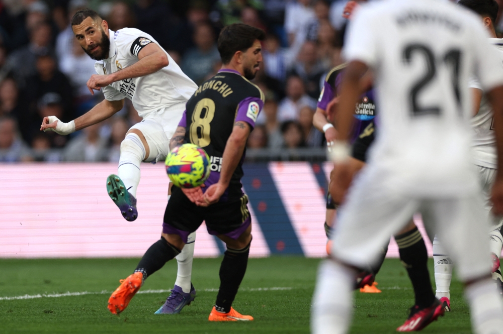 Real Madrid's French forward Karim Benzema (L) is challenged by Real Valladolid's Spanish midfielder Ramon Rodriguez 'Monchu' during the Spanish league football match between Real Madrid CF and Real Valladolid FC at the Santiago Bernabeu stadium in Madrid on April 2, 2023. Thomas COEX / AFP
