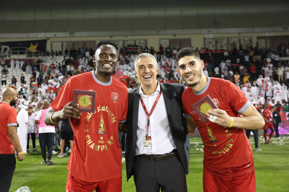 Al Duhail coach Hernan Crespo (centre) poses for a picture with Michael Olunga (left) and Karim Boudiaf after winning Qatar Cup final against Al Sadd at Jassim Bin Hamad Stadium on Thursday night.    