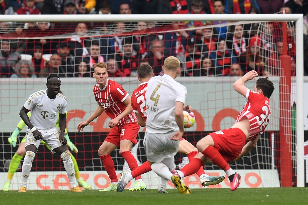 Bayern Munich's Dutch defender Matthijs de Ligt (C) scoring the opening goal during the German first division Bundesliga football match between SC Freiburg and Bayern Munich in Freiburg on April 8, 2023. (Photo by Thomas KIENZLE / AFP) 