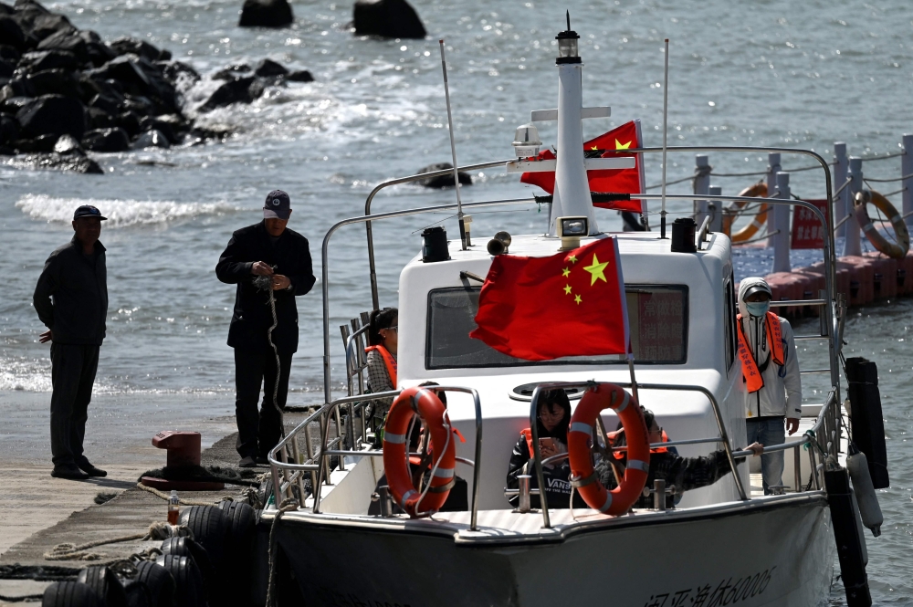 Tourists prepare to go on a boat cruise along the coast of Pingtan island, opposite Taiwan, in China's southeast Fujian province on April 9, 2023. China was conducting a second day of military drills around Taiwan on April 9, in what it has called a 