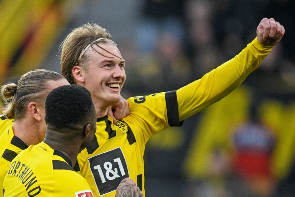 In this file photo taken on February 4, 2023 Dortmund's German midfielder Julian Brandt (R) celebrates scoring the 4-1 goal with his teammtes during the German first division Bundesliga football match between Borussia Dortmund v SC Freiburg in Dortmund, western Germany. Photo by SASCHA SCHUERMANN / AFP