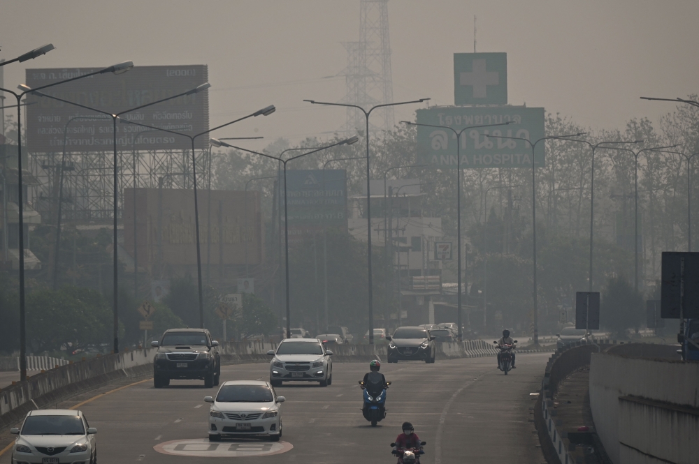 Commuters drive through high levels of air pollution in Chiang Mai on April 11, 2023. Photo by Lillian SUWANRUMPHA / AFP