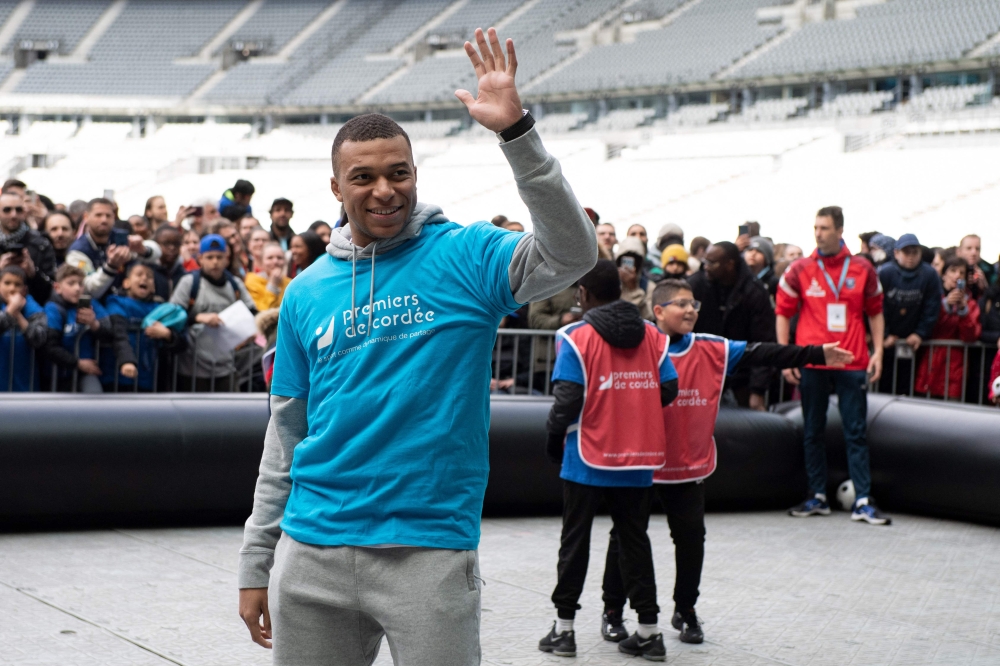 Paris Saint-Germain's and France's international football team French forward Kylian Mbappe takes part in a football match with children from the 