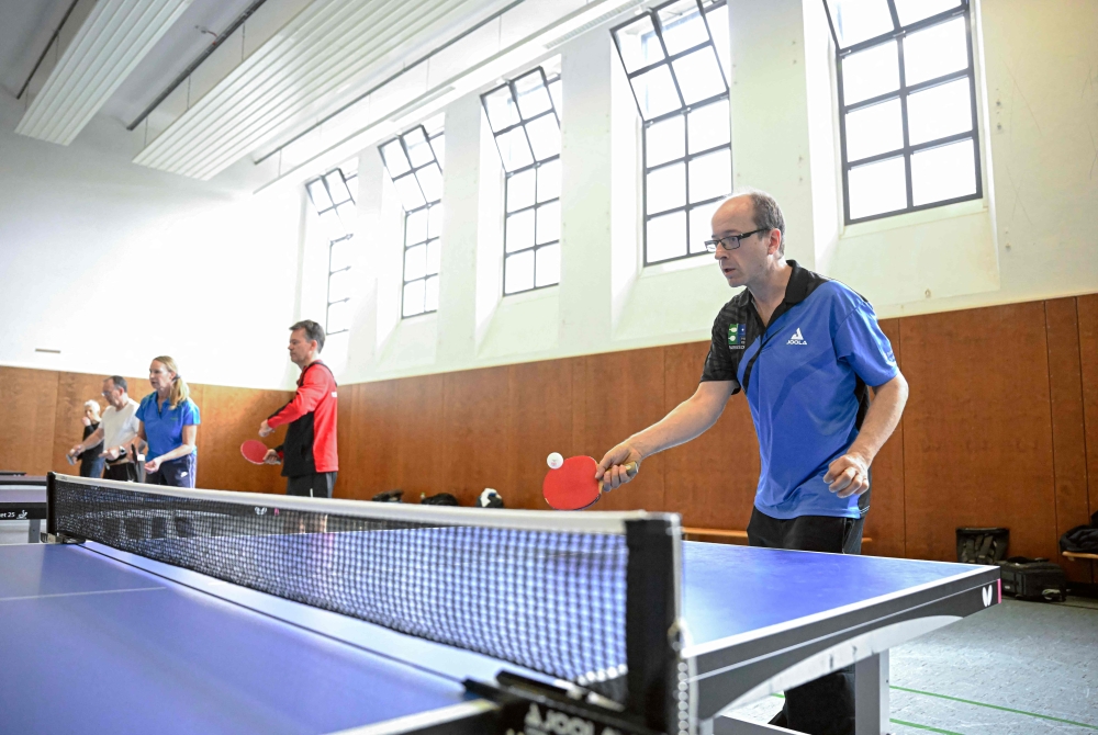 People play table tennis at the Ping Pong Parkinson initiative in Berlin on April 11, 2023, the World Parkinson's Day. Photo by Tobias SCHWARZ / AFP