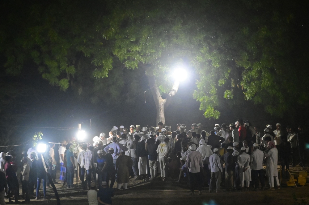 Mourners gather alongside the bodies of a former Indian member of parliament Atiq Ahmed and his brother Ashraf Ahmed after they were shot dead by gunmen outside Kalvin Hospital while being taken for a medical checkup in police custody, in Prayagraj on April 16, 2023. (Photo by Sanjay Kanojia / AFP)