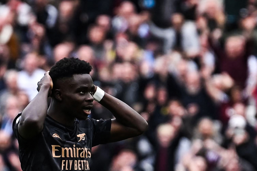 Arsenal's English midfielder Bukayo Saka reacts after missing to score a penalty kick during the English Premier League football match between West Ham United and Arsenal at the London Stadium, in London on April 16, 2023. (Photo by Ben Stansall / AFP)
