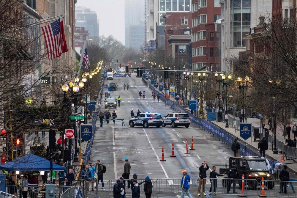Workers clean the wet finish line during the 127th Boston Marathon in Boston, Massachusetts, on April 17, 2023. Photo by Joseph Prezioso / AFP