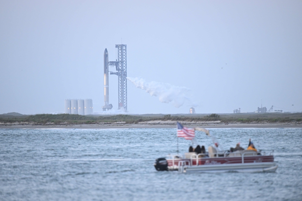 People wait on a boat to watch the launch of the SpaceX Starship rocket from South Padre Island, Texas on April 17, 2023. Photo by Patrick T. Fallon / AFP