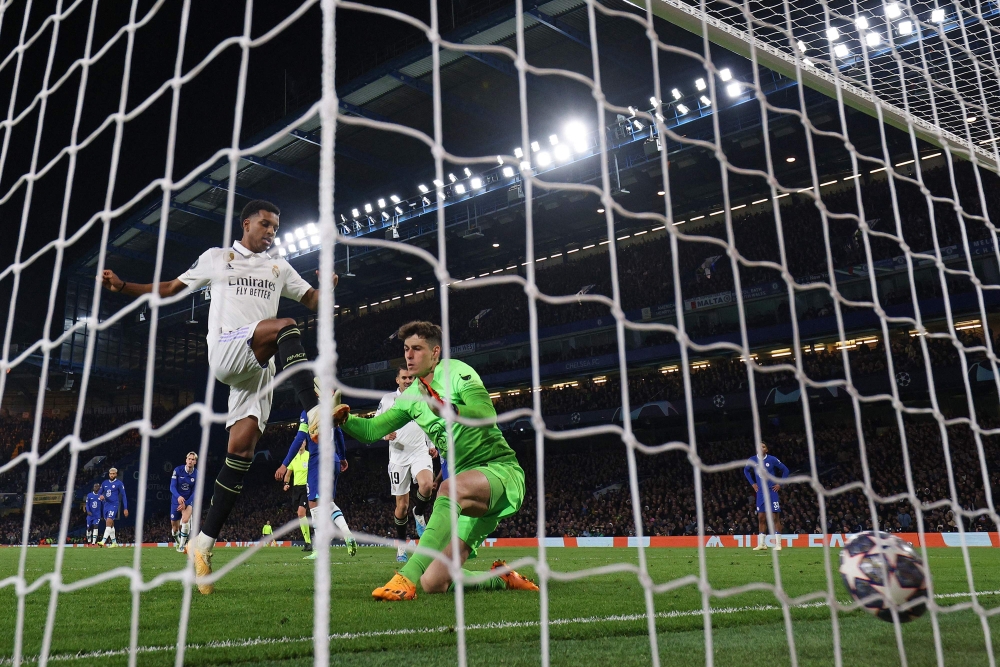 Real Madrid's Brazilian striker Rodrygo scores the team's second goal Chelsea's Spanish goalkeeper Kepa Arrizabalaga during the Champions League quarter-final second-leg football match between Chelsea and Real Madrid at Stamford Bridge in London on April 18, 2023. (Photo by Adrian DENNIS / AFP)