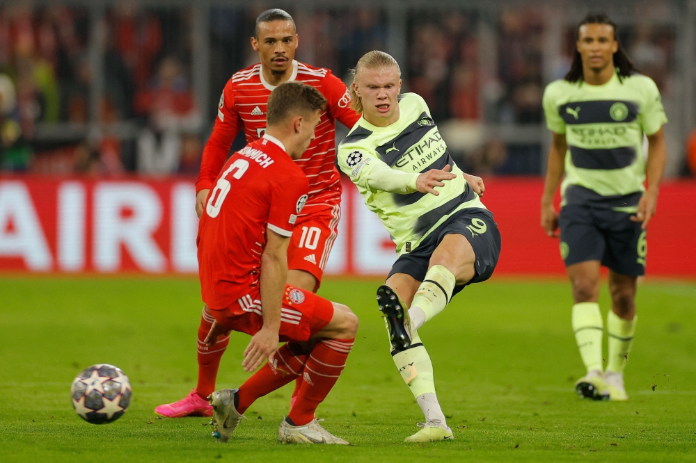 Manchester City's Norwegian striker Erling Haaland gets a shot away past Bayern Munich's German midfielder Joshua Kimmich during the UEFA Champions League quarter-final, second leg football match between Bayern Munich and Manchester City in Munich, southern Germany on April 19, 2023. (Photo by Odd ANDERSEN / AFP)