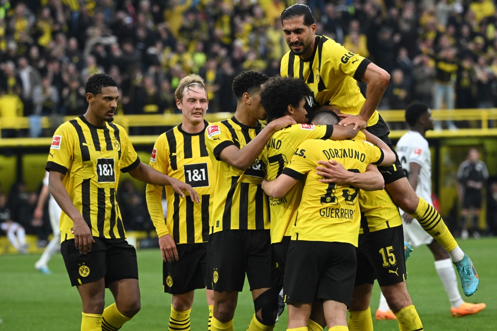 :Dortmund's German defender Mats Hummels (R - Hidden) celebrates scoring his team's third goal with his team mates during the German first division Bundesliga football match between BVB Borussia Dortmund and Eintracht Frankfurt in Dortmund, western Germany, on April 22, 2023. (Photo by INA FASSBENDER / AFP) 
