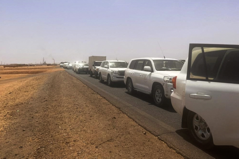 A convoy leaving Khartoum advances on a road towards Port Sudan, on April 23, 2023, as people flee the battle-torn Sudanese capital. (Photo by Abubakarr JALLOH / AFP)