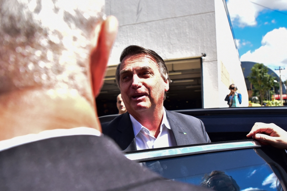 Brazilian former President Jair Bolsonaro speaks to the press while leaving the Federal Police headquarters after testifying in Brasilia on April 26, 2023. (Photo by TON MOLINA / AFP)
