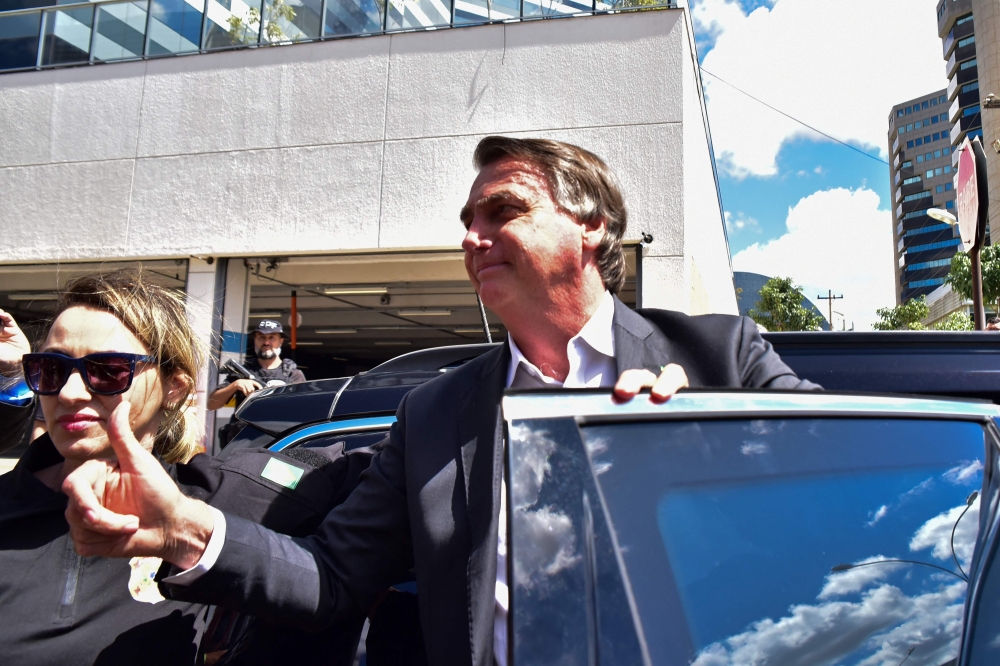 Former Brazilian President Jair Bolsonaro gestures while leaving the Federal Police headquarters after testifying in Brasilia on April 26, 2023. (Photo by TON MOLINA / AFP)