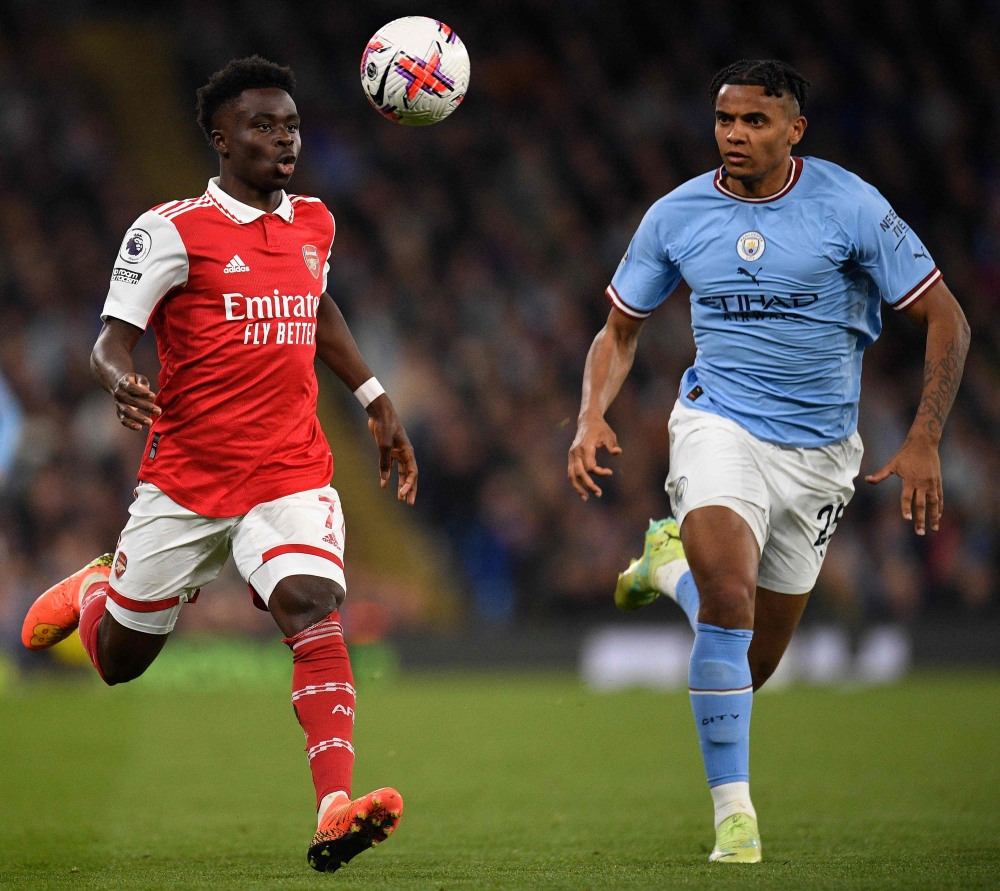 Manchester City's Swiss defender Manuel Akanji (R) vies against Arsenal's English midfielder Bukayo Saka during the English Premier League football match between Manchester City and Arsenal at the Etihad Stadium in Manchester, northwest England, on April 26, 2023. Photo by Oli SCARFF / AFP