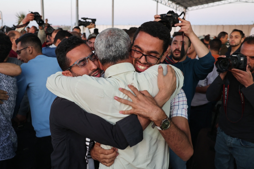 Relatives welcome Palestinian evacuees from war-torn Sudan upon arrival to the Gaza Strip through the Rafah border crossing with Egypt, on April 28, 2023. (Photo by SAID KHATIB / AFP)