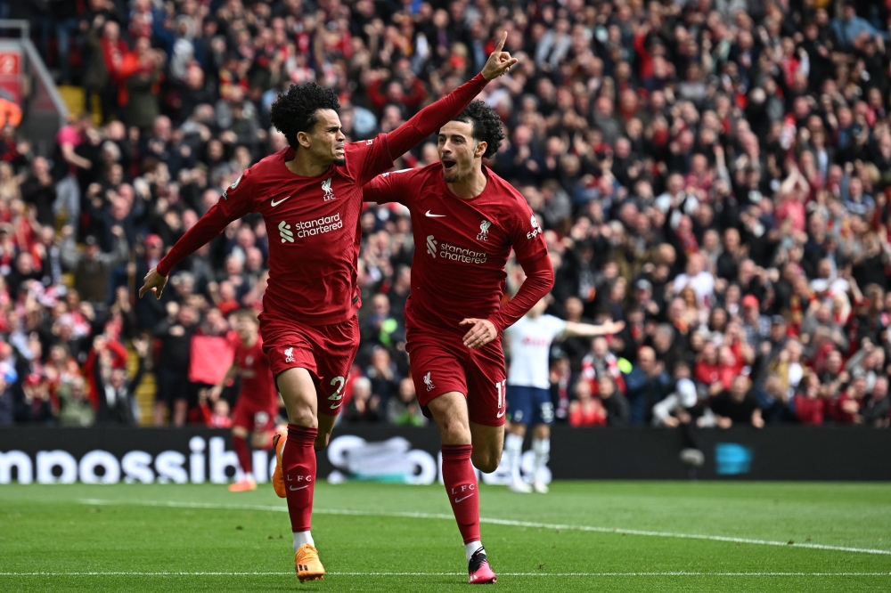 Liverpool's Colombian midfielder Luis Diaz (L) celebrates with Liverpool's English midfielder Curtis Jones (R) after scoring their second goal during the English Premier League football match between Liverpool and Tottenham Hotspur at Anfield in Liverpool, north west England on April 30, 2023. (Photo by Paul ELLIS / AFP)