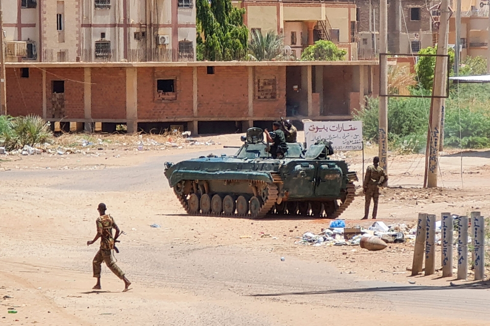 Sudanese Army sodliers walk near tanks stationed on a street in southern Khartoum, on May 6, 2023, amid ongoing fighting against the paramilitary Rapid Support Forces. Photo by AFP