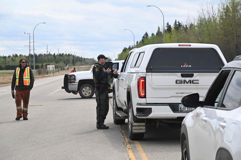 An Alberta Fish and Wildlife officer deters drivers at police roadblock outside the town of Drayton Valley, Alberta, Canada on May 7, 2023. Photo by Walter Tychnowicz / AFP