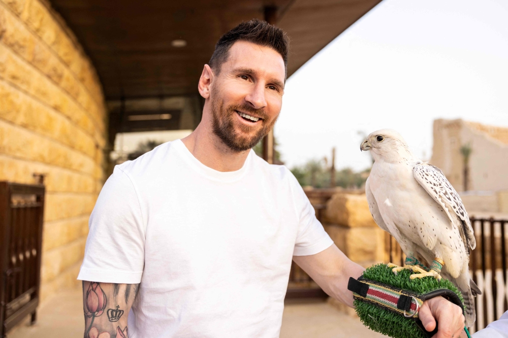 (Files) This file handout photo taken on May 01, 2023, and provided by the Saudi Tourism Authority shows Argentina's forward Lionel Messi holding a falcon in Riyadh. (Photo by Saudi Tourism Authority / AFP) 