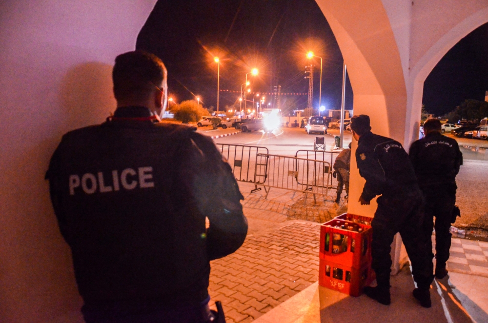 In this picture taken on May 9, 2023, police take positions near the Ghriba synagogue during a shootout on the resort island of Djerba. (Photo by Yassine MAHJOUB / AFP)