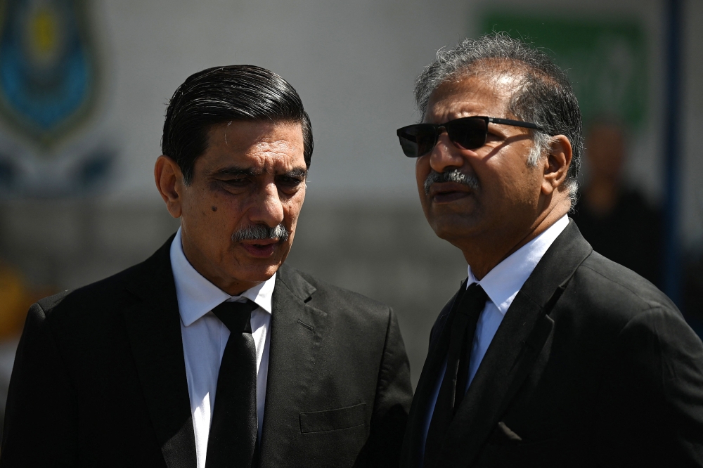 Khawaja Haris (L) and Ali Zafar, members of the legal team of former Pakistan's Prime Minister Imran Khan, wait to attend a hearing near the police headquarters, in Islamabad on May 10, 2023. (Photo by Aamir Qureshi / AFP)