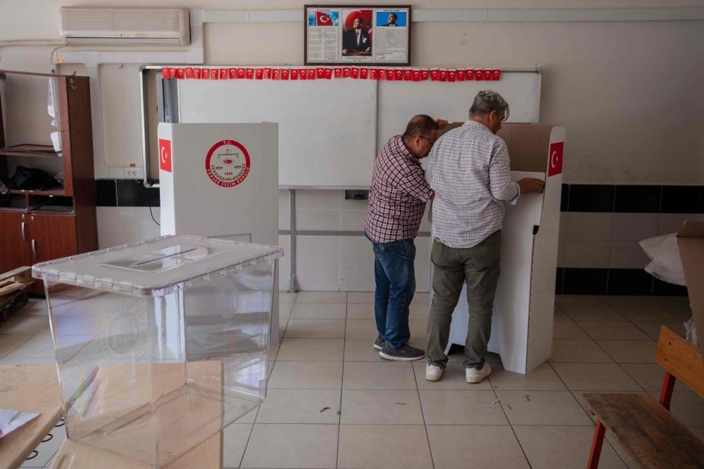 Teachers prepare ballot boxes and cardboard voting booths at a school in Antakya, on May 13, 2023. (Photo by Can Erok / AFP)