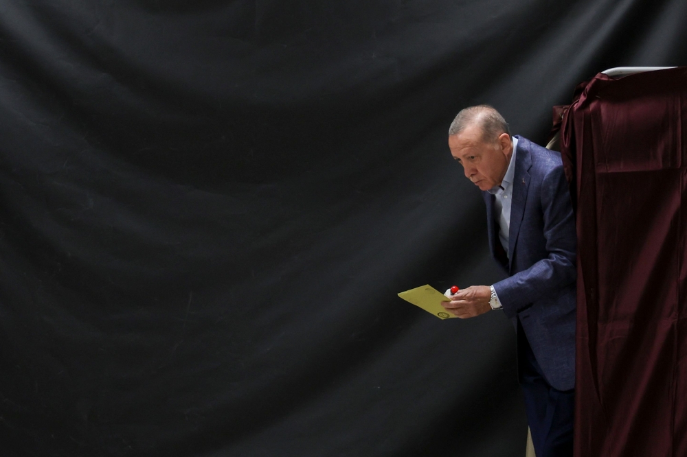 Turkish President Tayyip Erdogan walks out of a voting booth at a polling station to vote in the presidential and parliamentary elections, in Istanbul, on May 14, 2023. (Photo by UMIT BEKTAS / POOL / AFP)