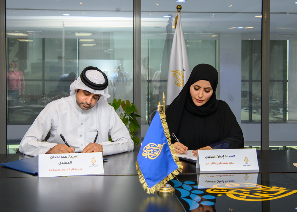 Director of QOC Support Services Sector Hamad Lahdan Al Mohannadi and Director of Al Jazeera Media Institute Iman Ahmed Al Amri signing the contract. 