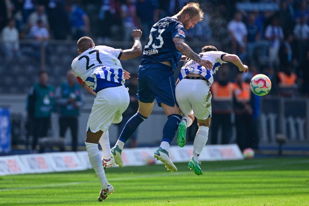 :Hertha Berlin's Ghanaian midfielder Kevin-Prince Boateng (L), Bochum's German forward Philipp Hofmann (C) and Hertha Berlin's German forward Marco Richter vie for a header during the German first division Bundesliga football match between Hertha Berlin and VfL Bochum in Berlin, Germany, on May 20, 2023. (Photo by John MACDOUGALL / AFP) 