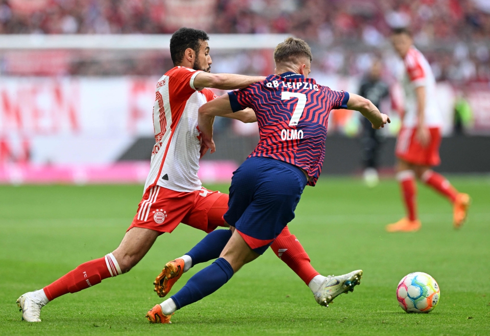 Bayern Munich's Moroccan defender Noussair Mazraoui (L) and Leipzig's Spanish midfielder Dani Olmo vie for the ball during the German first division Bundesliga football match between FC Bayern Munich and RB Leipzig in Munich, southern Germany, on May 20, 2023. (Photo by Christof STACHE / AFP)