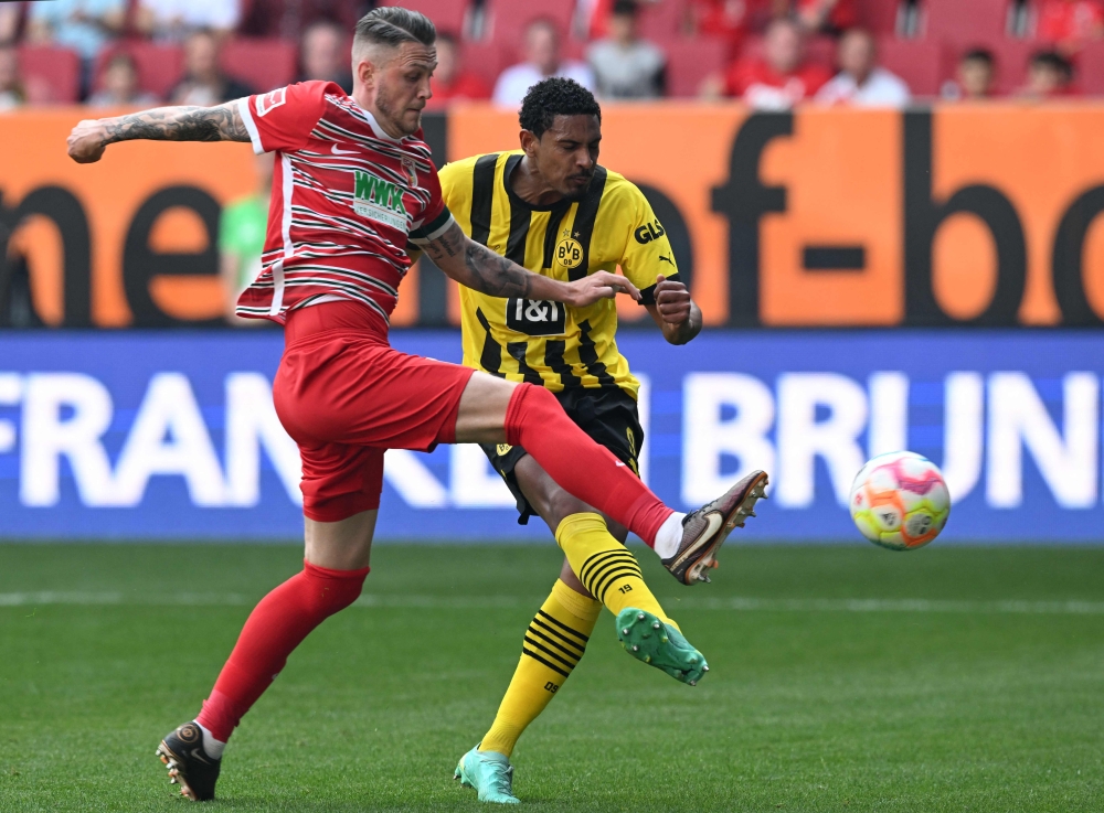 Dortmund's French forward Sebastien Haller (R) and Augsburg's Dutch defender Jeffrey Gouweleeuw vie for the ball during the German first division Bundesliga football match between FC Augsburg and BVB Borussia Dortmund in Augsburg, southern Germany, on May 21, 2023. (Photo by Christof STACHE / AFP)