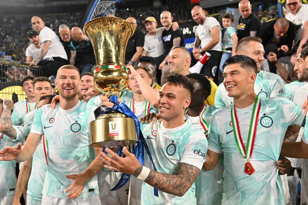 Inter Milan's Argentinian forward Lautaro Martinez (C) celebrates with the trophy after winning the Italian Cup (Coppa Italia) final football match between Fiorentina and Inter Milan at the Stadio Olimpico in Rome, on May 24, 2023. (Photo by Alberto PIZZOLI / AFP)
