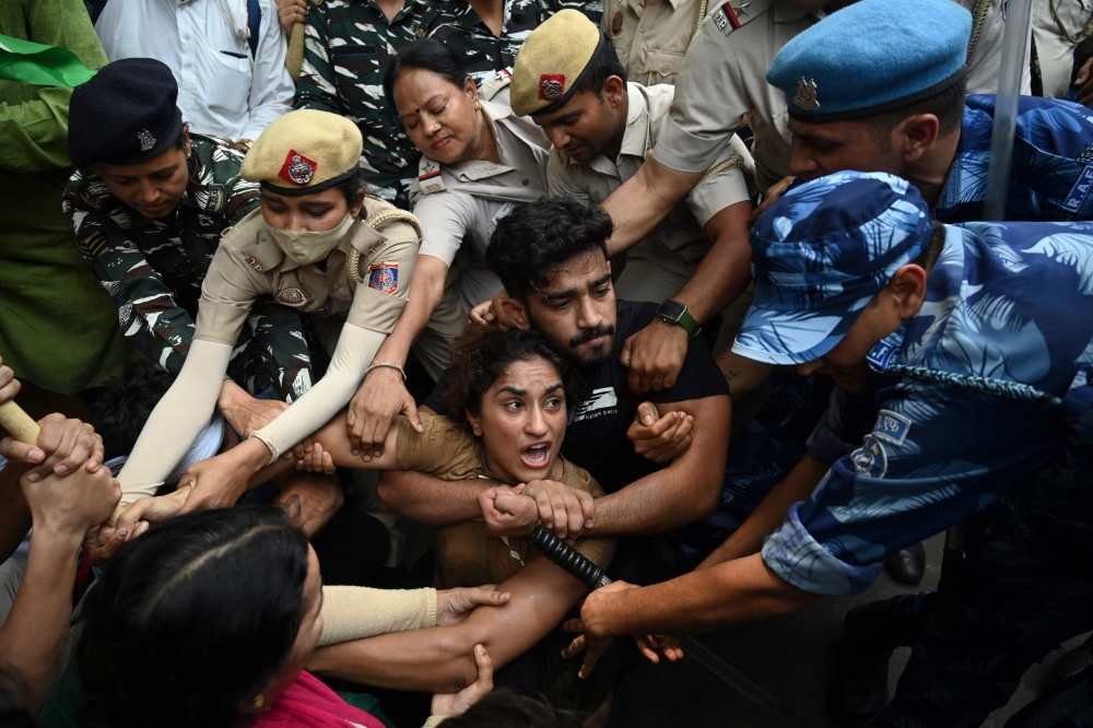 Indian wrestlers Vinesh Phogat (C) with others are detained by the police while attempting to march to India's new parliament, just as it was being inaugurated by Prime Minister Narendra Modi, in New Delhi on May 28, 2023. (Photo by Arun Thakur / AFP)