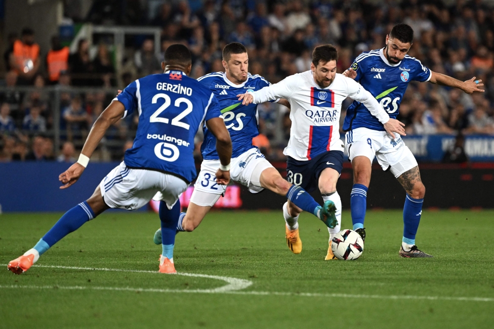 Paris Saint-Germain's Argentine forward Lionel Messi fights for the ball with Strasbourg's French defender Frederic Guilbert (L) and Strasbourg's French midfielder Morgan Sanson (R) during the French L1 football match between RC Strasbourg Alsace and Paris Saint-Germain (PSG) at Stade de la Meinau in Strasbourg, eastern France on May 27, 2023. (Photo by Patrick Hertzog / AFP)