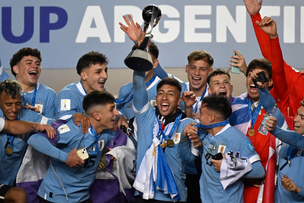 Uruguay's midfielder Fabricio Diaz (C) holds the trophy along with his teammates after defeating Italy and winning the Argentina 2023 U-20 World Cup at the Estadio Unico Diego Armando Maradona stadium in La Plata, Argentina, on June 11, 2023. (Photo by Luis ROBAYO / AFP)
