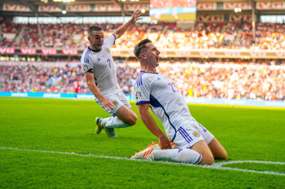 Scotland's midfielder John McGinn (L) and Scotland's midfielder Kenny McLean celebrate after their team scored during the UEFA Euro 2024 group A qualification football match between Norway and Scotland in Oslo on June 17, 2023. (Photo by Fredrik Varfjell / NTB / AFP)
