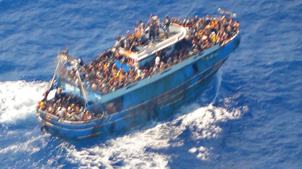 File photo of  migrants onboard a fishing vessel in the waters off the Peloponnese coast of Greece on June 13, 2023. (Photo by Hellenic Coastguard / AFP)