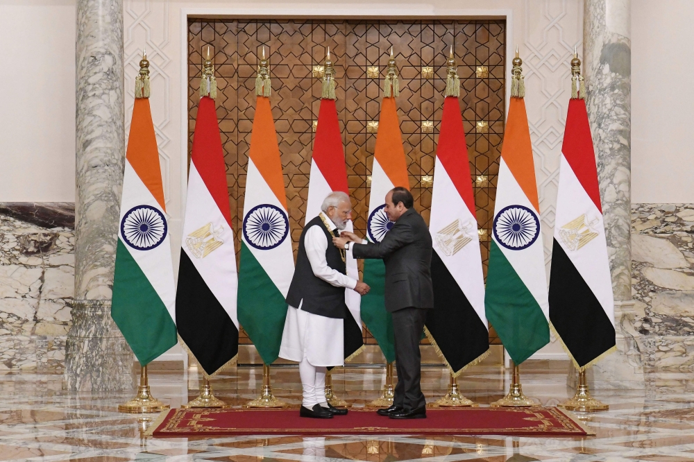 A handout picture released by the Egyptian Presidency on June 25, 2023 shows Egyptian president Abdel Fattah al-Sisi (right) granting the Order of the Nile medal to the Indian Prime Minister Narendra Modi in the capital Cairo. (Photo by AFP)