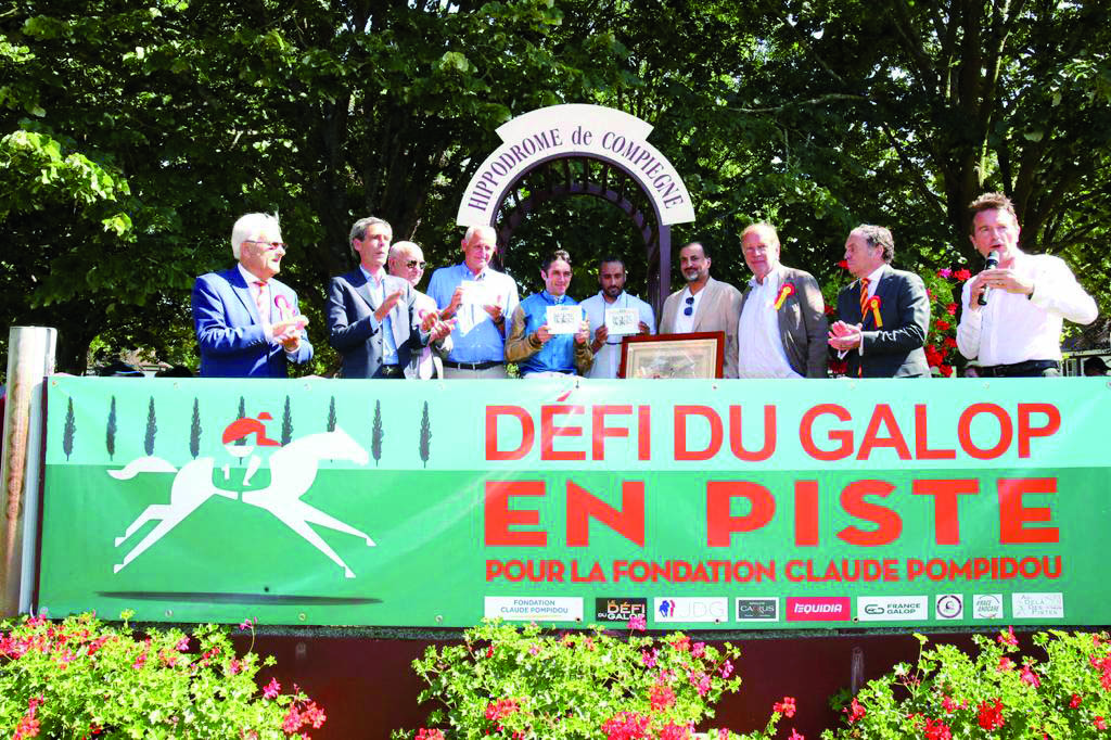 The connection of Bolthole pose for a photograph with officials during the presentation ceremony after the Wathnan Racing-owned four-year-old horse won the Listed Grand Prix de Compiegne. LEFT: Christophe Soumilllon (second right) guides Bolthole towards the finish line.
