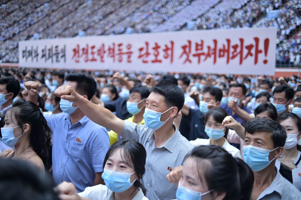 In this photo taken on June 25, 2023, residents of Pyongyang hold a banner that reads 