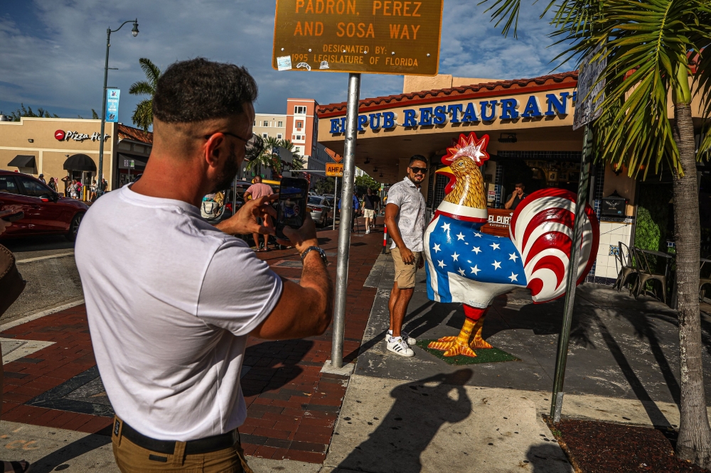 Tourists take photos with the distinctive rooster on 8th Street in Little Havana, Miami, Florida during on June 26, 2023. (Photo by Giorgio Viera / AFP)