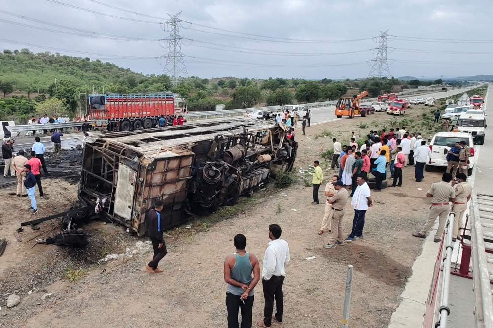 A policeman inspects the wreckage of a bus that caught fire along the Samruddhi Expressway near Sindkhed Raja in Buldhana district of Maharashtra state on July 1, 2023.  (Photo by Gajanan Mehetre / AFP)