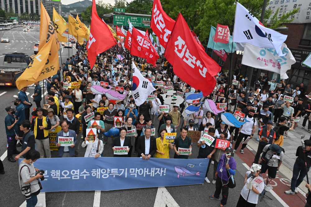 South Korean protesters stage a rally against Japan's plan to discharge treated water from the Fukushima nuclear plant, on a road near the Japanese embassy in Seoul on July 8, 2023. (Photo by Jung Yeon-je / AFP)
