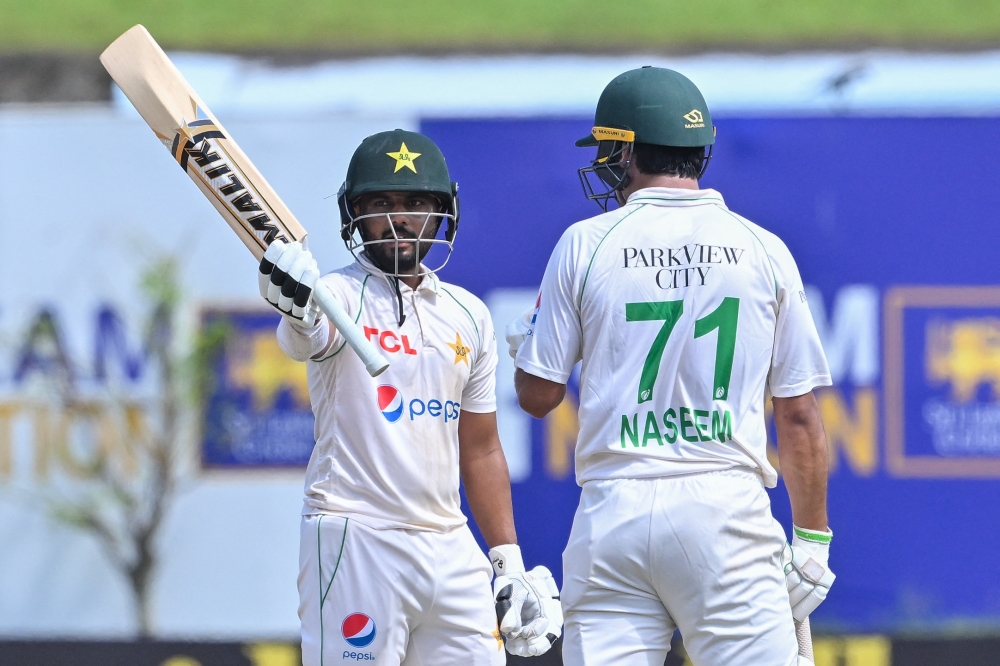 Pakistan's Saud Shakeel (L) celebrates 150 runs as his teammate Naseem Shah watches during the third day of the first cricket Test match between Sri Lanka and Pakistan at the Galle International Cricket Stadium in Galle on July 18, 2023. (Photo by Ishara S. Kodikara / AFP)